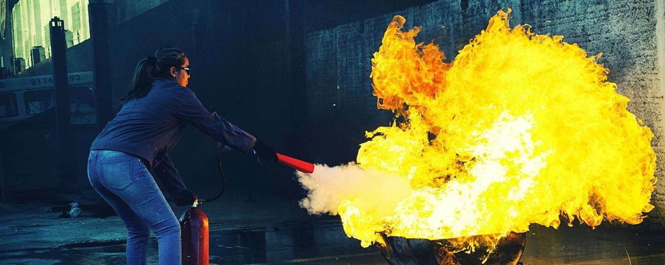 formation incendie obligatoire pour entreprise, un personnel se forme avec un extincteur et un bac à feu réel