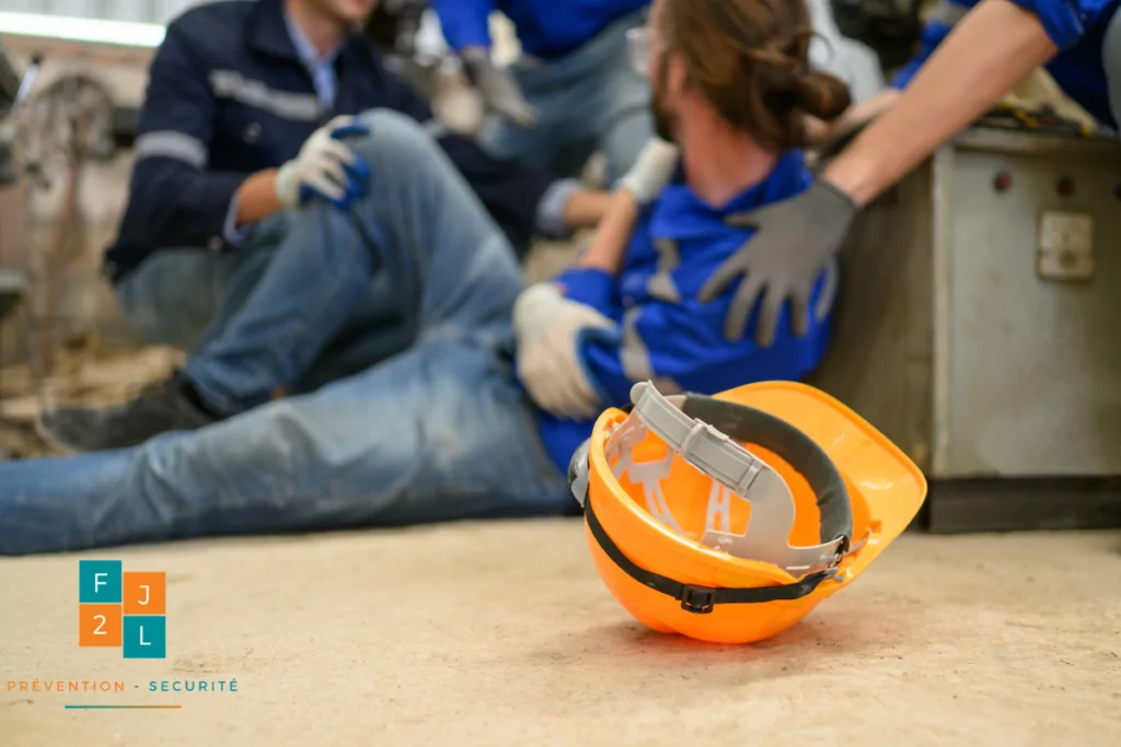 Un accident du travail avec un travailleur au sol assisté par des collègues, illustrant les conséquences potentielles de l'absence du DUERP.